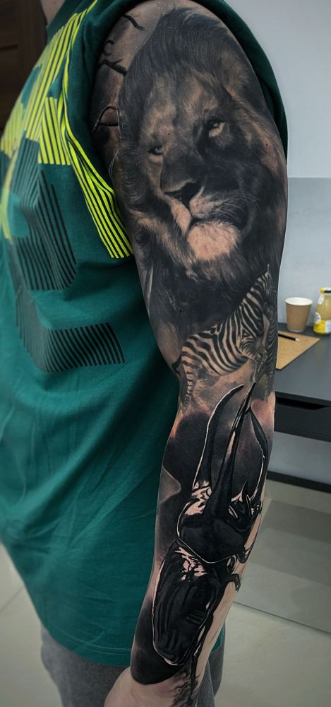 duży lew i chrabąszcz tatuaż na ręce