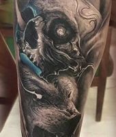 wilk i czaszka tatuaż na łydce