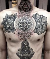 duży krzyż z symboli na brzuchu - tatuaż mandala