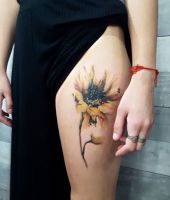 żółty kwiatek tatuaż na udzie