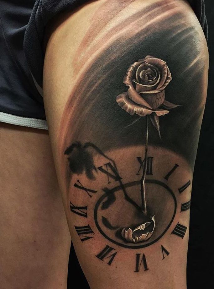 tarcza zegara i róża - tatuaż na udzie