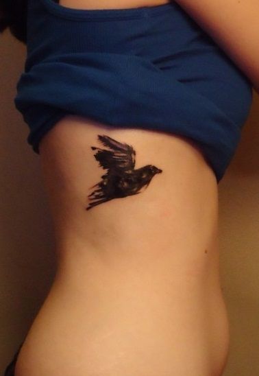 mały ptak tatuaż na żebrach