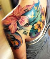 lilie i zegar tatuaże na ramieniu
