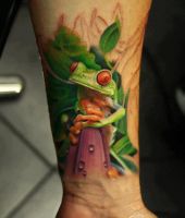 zielona żaba tatuaż na ręce