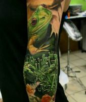 zielona żaba i kobieta tatuaże na ręce