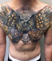 duża sowa wytatuowana na klatce piersiowej