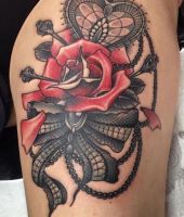 róża z kokardką tatuaż na udzie