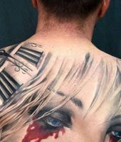 duży tatuaż z tarczą zegara i twarzą kobiety