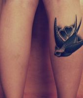 jaskółka i dwa serca tatuaże na łydce