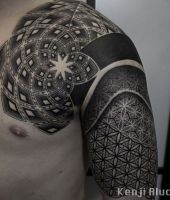 czarne kropkowane tatuaże na ramieniu