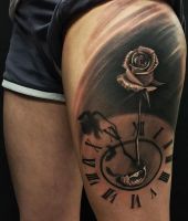 zegar i róża tatuaż na udzie