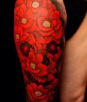 czerwone kwiaty tatuaże na udzie
