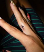 mały krzyżyk tatuaż na palcu