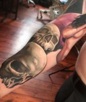 białe czaszki wytatuowane na ręce