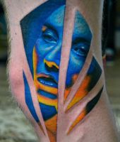 niebieska twarz tatuaż na kolanie