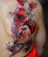 ptak wśród kwiatów tatuaż na plecach