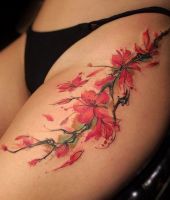 czerwone kwiatki tatuaże na biodrze