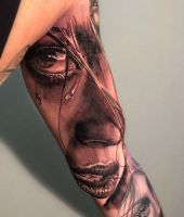 tatuaz z twarzą kobiety na ramieniu