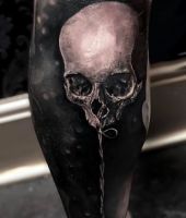 róża tatuaż na łydce z czaszką