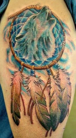 wilk i łapacz snów tatuaż na ramieniu